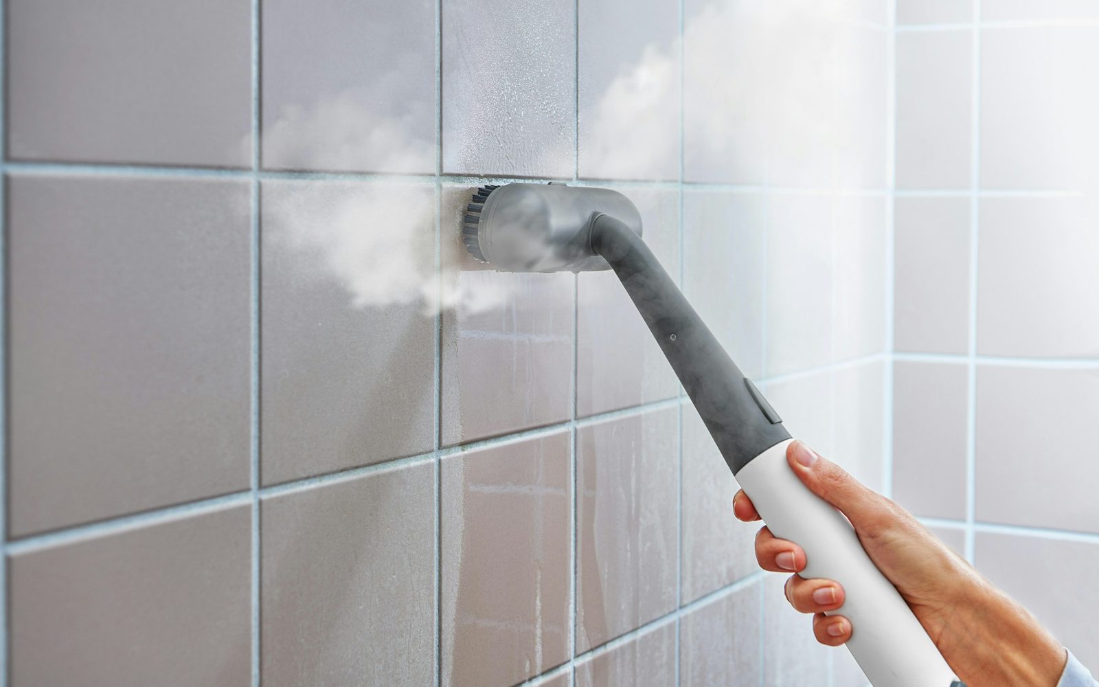 Vaporizadora profesional desinfectando las juntas de una pared de azulejos
